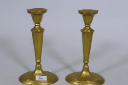 A pair of antique brass candlesticks, 25cm high