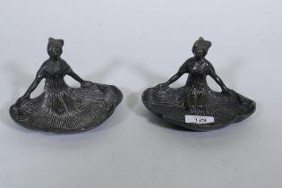 A pair of bronze dishes in the form of kneeling women with fanned skirts, 10cm high