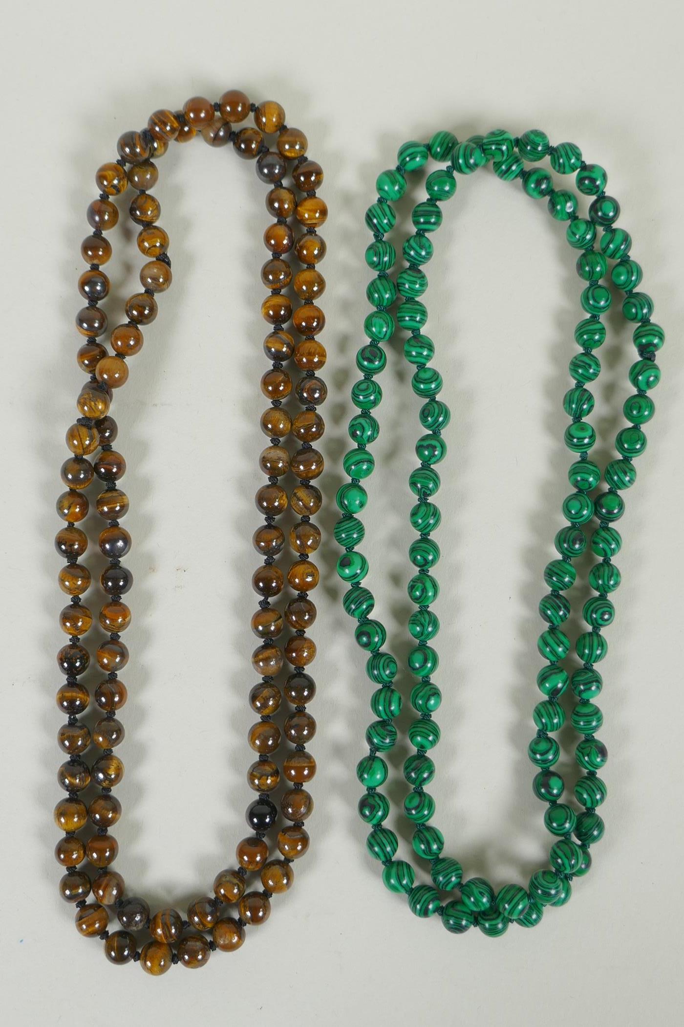 A string of tiger's eye beads, and a string of malachite style beads, longest 95cm