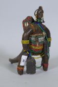 An African doll figure, bound with beads to a horn stand, 26cm high