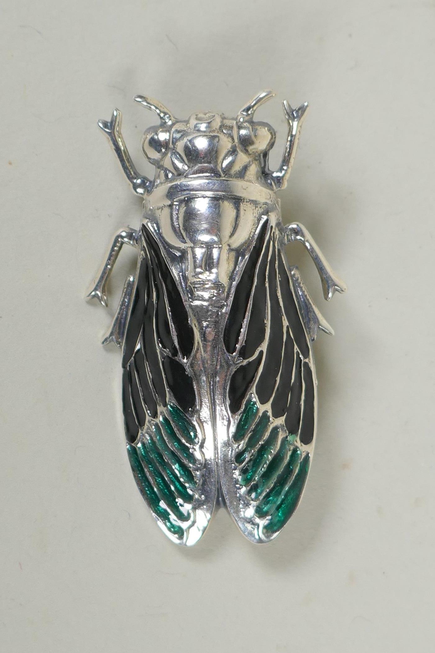 A sterling silver and enamel brooch in the form of a cicada, 5cm