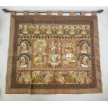 An antique Tibetan embroidered and beaded silk textile hanging, decorated with depictions of Buddha,