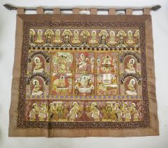 An antique Tibetan embroidered and beaded silk textile hanging, decorated with depictions of Buddha,