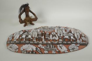 A New Guinea carved wood primitive figure together with a carved New Guinea Kambot storyboard panel,