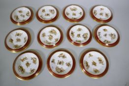 A set of eleven Copeland china dessert dishes, with red borders and raised gilt decoration of sea-