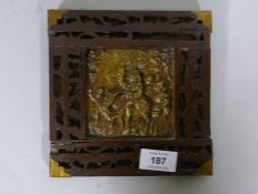An antique Folk Art wood panel with fret borders and metal mounts, the brass plaque with repousse