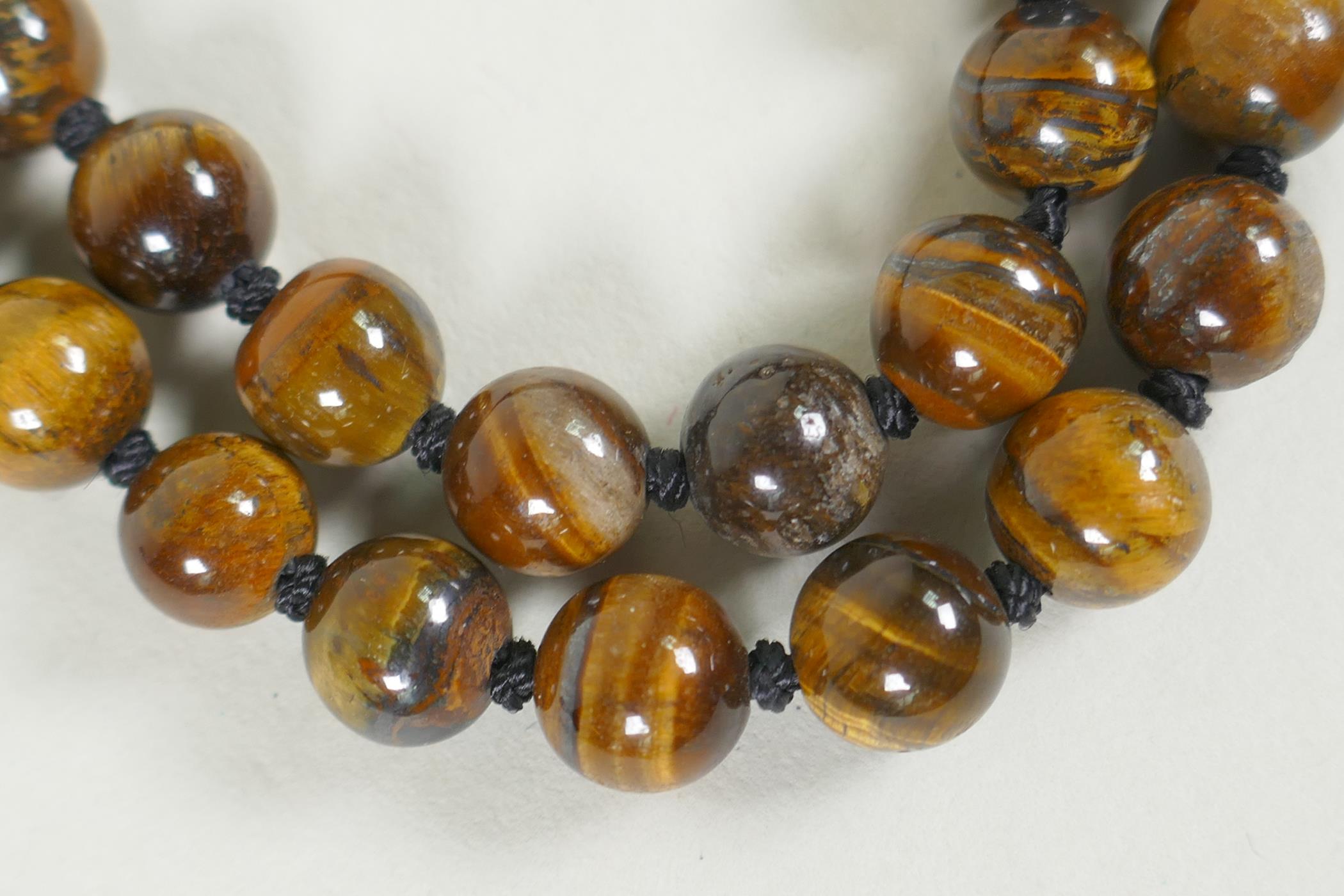 A string of tiger's eye beads, and a string of malachite style beads, longest 95cm - Image 2 of 3