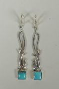 A pair of sterling silver drop earrings in the form of dolphins, set with two turquoise stones, 6cm