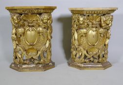A pair of early C19th carved and giltwood pine pedestals/stands, decorated with winged putti and