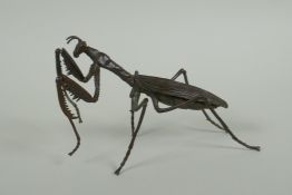 A Japanese style bronze okimono of a mantis, with articulated limbs, 15cm long