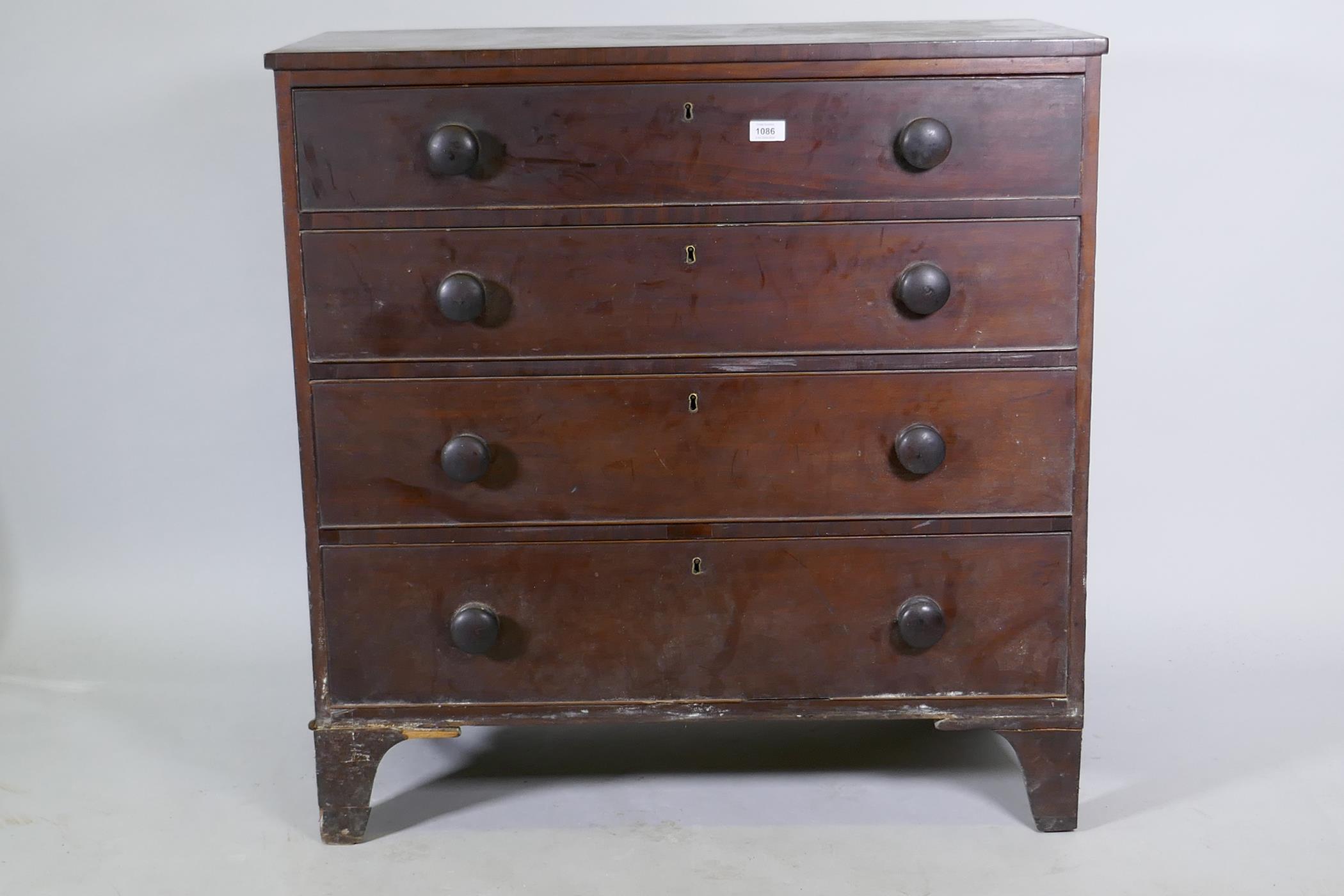 A Georgian mahogany chest of four long drawers, with cockbeaded detail and wooden knobs, raised on