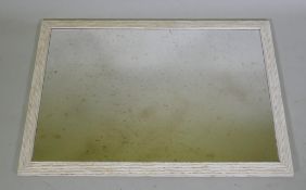 A painted and distressed wall mirror with a reeded frame and antiqued glass, 71 x 102cm