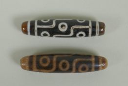 A pair of Tibetan agate dzi beads, 5.5cm long