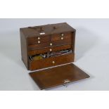 An antique mahogany tool chest containing vintage engineer's tools