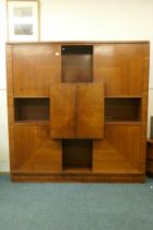 A Continental mid century rosewood cabinet with four doors around an open shelf and cupboards