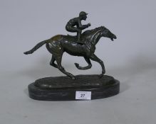 A bronze figure of a jockey on a racehorse, inscribed Coreira, mounted on a slate base, 24cm high