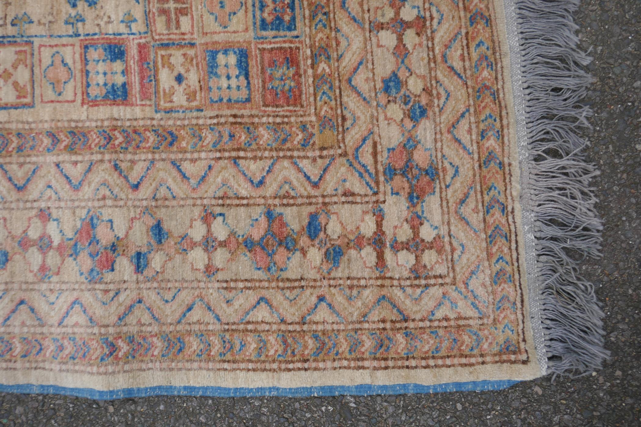 A Turkish gold ground wool rug with a blue geometric medallion design, 164 x 212cm - Image 3 of 4