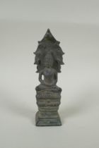 A Cambodian filled bronze figure of Buddha seated on a cobra throne, 22cm high