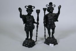 A pair of painted brass figural candlesticks in the form of Moors bearing torches, 40cm high
