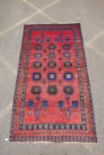 A vintage Persian Hamadan village rug with a unique design and colours on a red field, 140 x 256cm