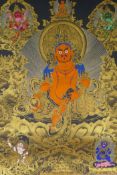 A Tibetan painted thangka depicting Jambhala, housed within a silk mount, 80 x 124cm