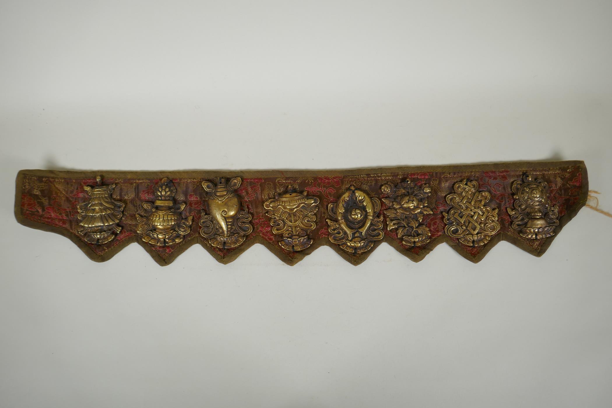 A Tibetan silk and linen belt with bronze mounts depicting the eight Buddhist treasures, 72cm long