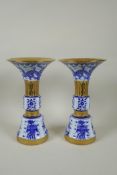 A pair of Chinese blue and white gu shaped vases with banded gilt highlights, and decorated with