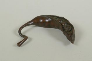 A Japanese style bronze okimono of a frog nestled in a pea pod 7cm long