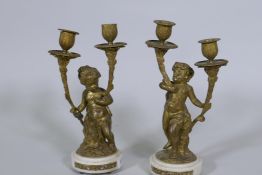A pair of C19th French ormolu bronze two branch candelabra in the form of putti bearing