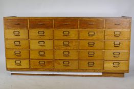An oak haberdasher's shop cabinet with glass top and sliding doors, the back with five flights of