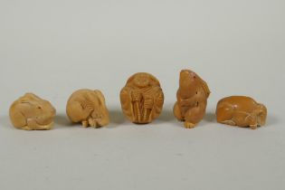 Five Japanese carved tagua nut netsuke in the form of hares, a buffalo and a Buddha, largest 4cm