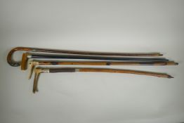 Four antique walking sticks with silver mounts and collars, two with carved antler handles,