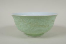 A Chinese celadon glazed porcelain rice bowl with underglaze dragon decoration, 5 character mark