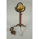 A brass and leather miniature terrestrial globe desk stand, and a replica brass compass, 27cm high