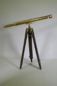 A brass telescope on telescopic wood stand, 98cm long, 104cm high