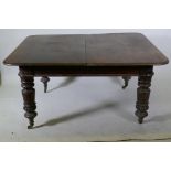 A Victorian mahogany pull out extending dining table raised on turned supports with carved