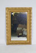 An antique carved giltwood framed wall mirror, 61 x 92cm