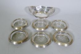 A set of six sterling silver crystal glass coasters, 9.5cm diameter, and a silver plated basket bowl