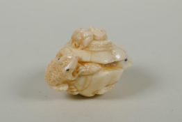 A Japanese carved bone netsuke in the form of frogs and a snake, signed to base, 4.5cm wide