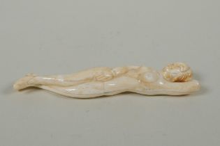 An oriental carved bone figure of a female nude, 13cm long