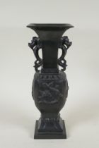 A Japanese bronze vase with twin dragon handles and raised dragon decoration to the side, indistinct