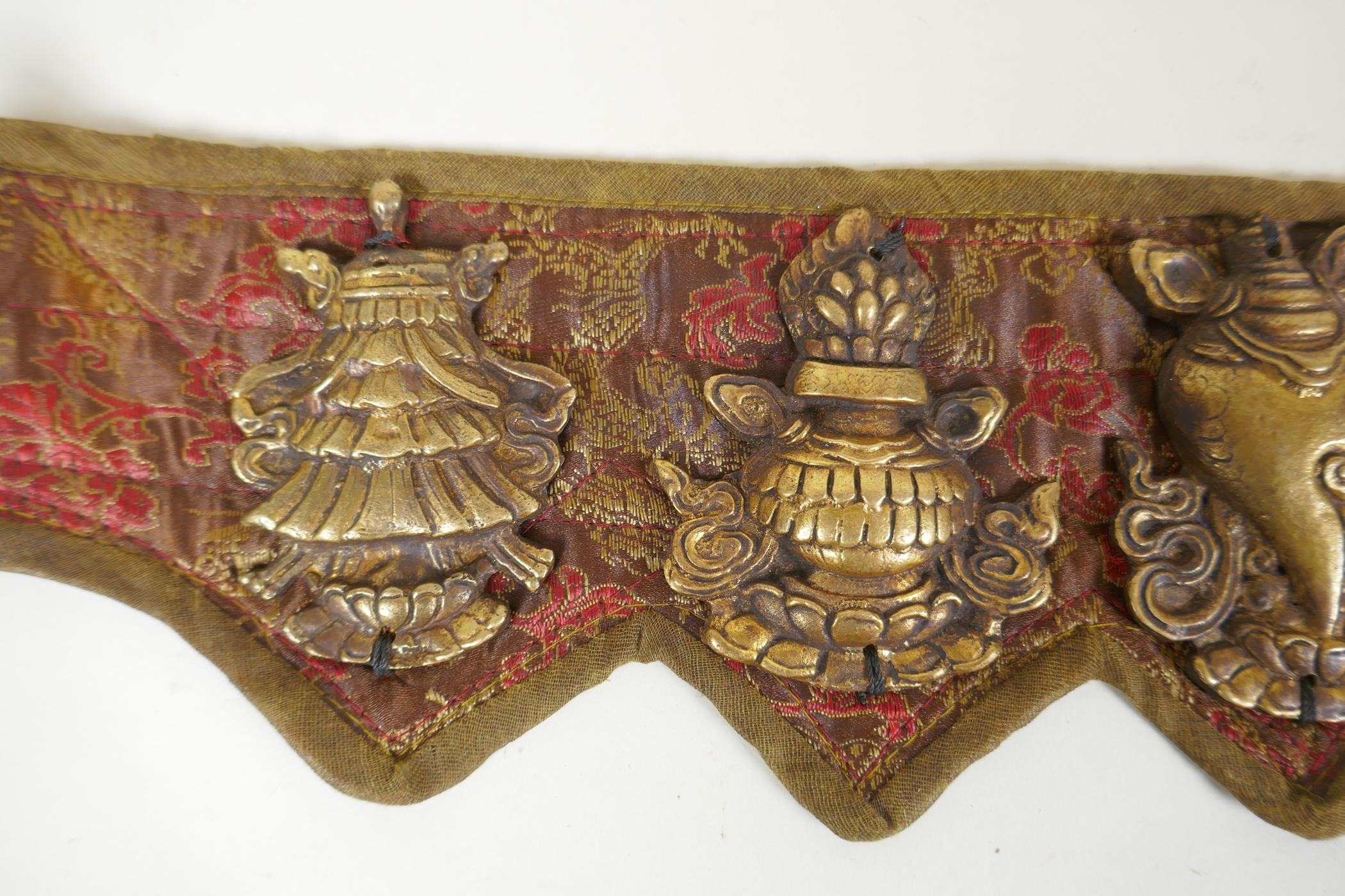 A Tibetan silk and linen belt with bronze mounts depicting the eight Buddhist treasures, 72cm long - Image 2 of 5