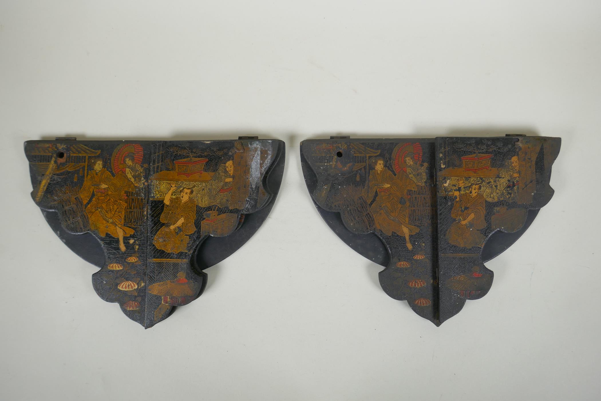 A pair of Japanese export Japanned papier mache folding brackets, decorated with geisha and their