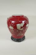 A Chinese red and white porcelain baluster vase, decorated with carp in a lotus pond, on a carved