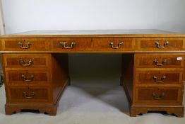 A Georgian style mahogany pedestal partner's desk, with nine drawers and two cupboards, brass swan