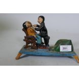 A painted cast iron money box in the form of a dentist, 22cm long, 16cm high