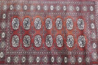 A Bokhara hand woven deep red ground rug with traditional pattern, 130 x 80cm