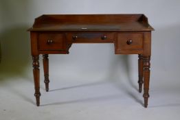 Early C19th mahogany kneehole desk of three drawers, with three quarter gallery top, raised on