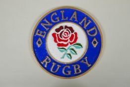 A 'England Rugby' painted cast iron wall plaque, 23cm diameter