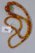 A string of vintage graduated butterscotch amber beads, largest 2.5cm long, 50g